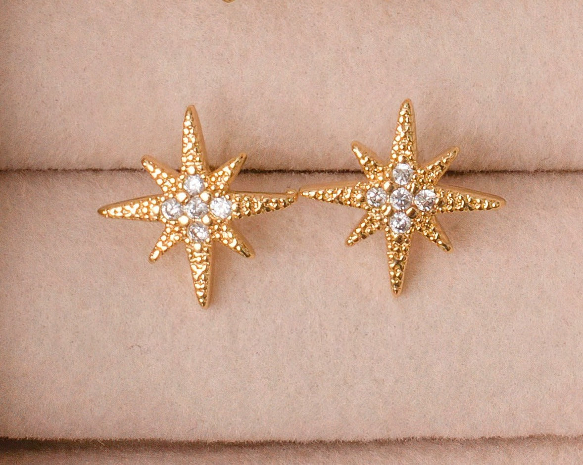 Gold Plated Star burst stud earrings with cubic zirconia center stones.