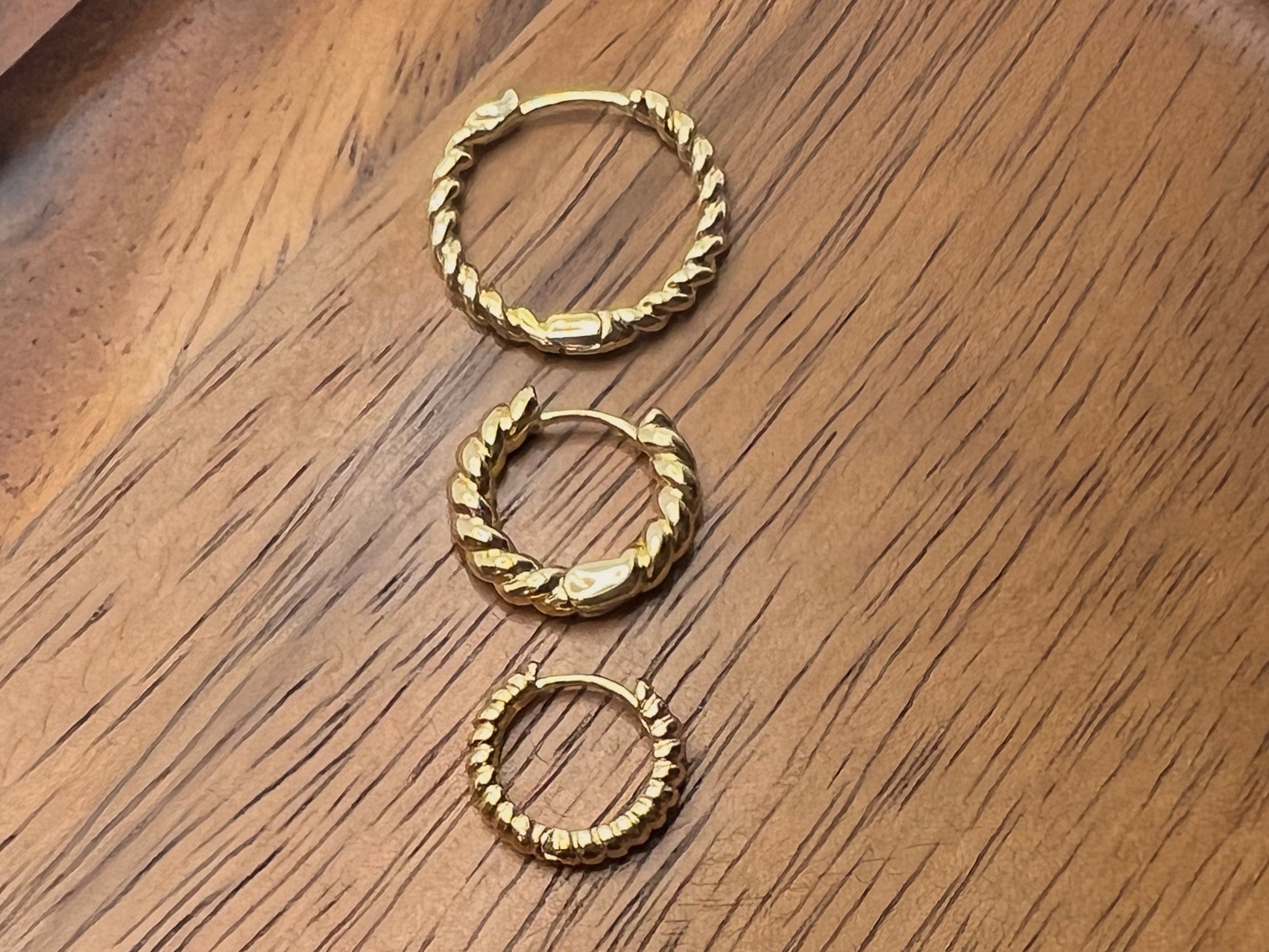 Three gold huggie hoops shown in size comparison picture. Pictured in order from left to right 20mm, 16mm, and 13mm.