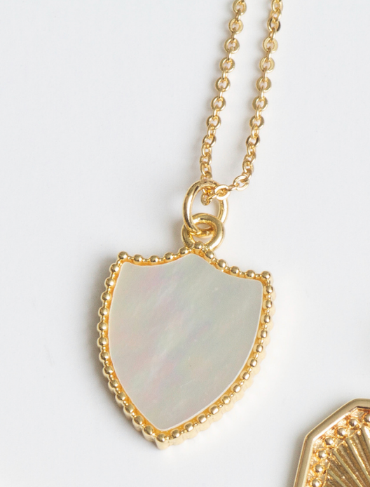 White shell shield shaped pendant on gold filled base with mini gold spheres surrounding pendant. With a 16" or 18.5 inch gold filled rolo chain