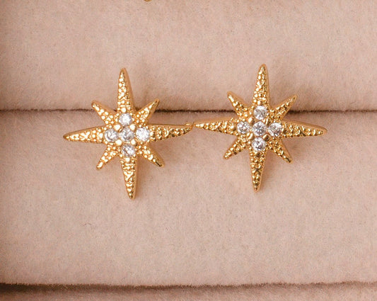 Gold Plated Star burst stud earrings with cubic zirconia center stones.