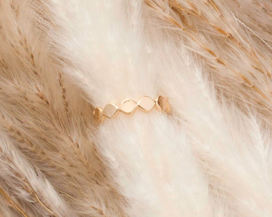 Gold ring with connected diamond shapes. Geometric look.