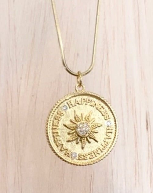 Round gold chain with coin pendant with the sun and happiness inscribed around the outer edge.