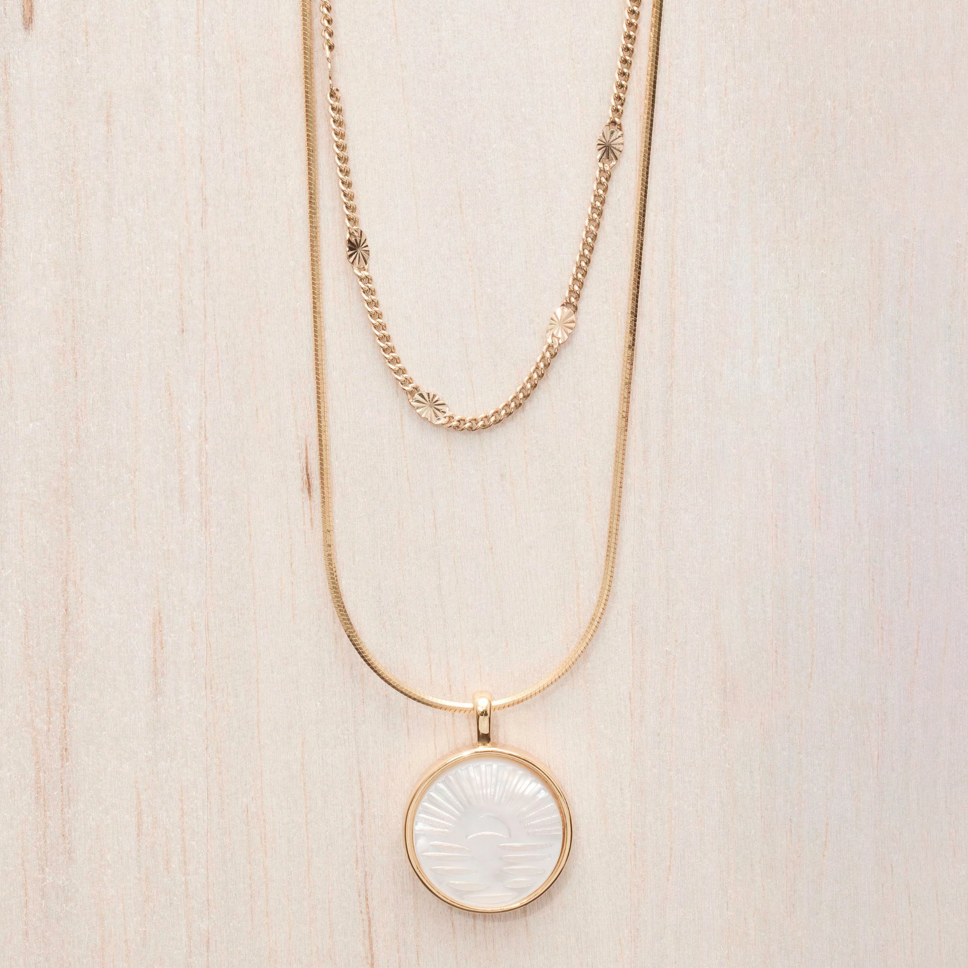 Gold filled necklace 18 inch or 20 inch round snake chain. Gold filled pearl shell sunrise coin pendant about 3/4". Picture also shows necklace paired with gleaming chain.