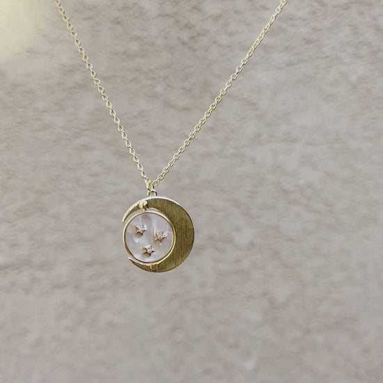 Gold necklace with moon, middle spinning pendant with white shell and gold stars