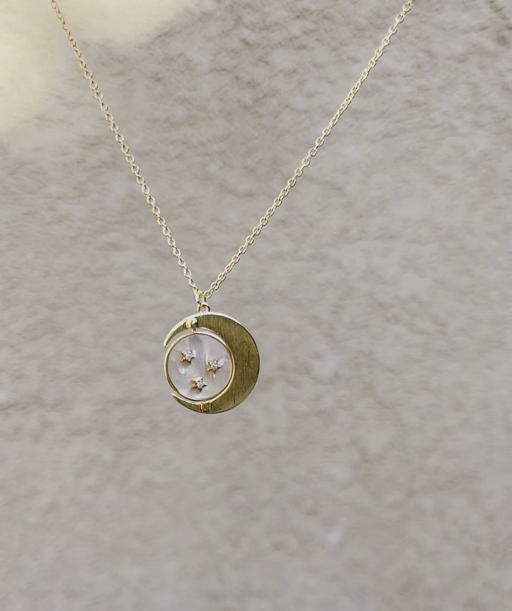 Gold necklace with moon, middle spinning pendant with white shell and gold stars